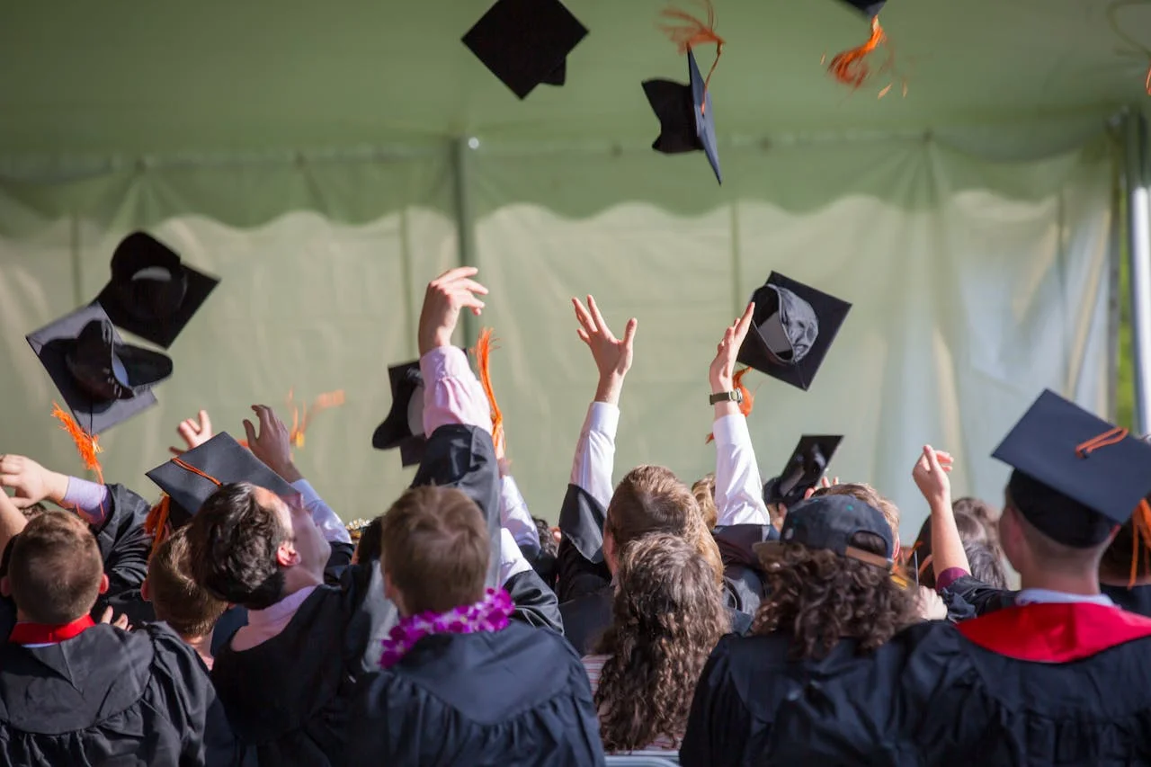 Graduates tossing graduation cap in the air